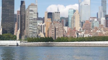 New York City rıhtımı, Manhattan Midtown binaları, East River nehir kıyısı gökdelenleri. Long Island, Queens 'ten deniz kenarı manzarası. Birleşik Devletler emlak mimarisi. Roosevelt Adası