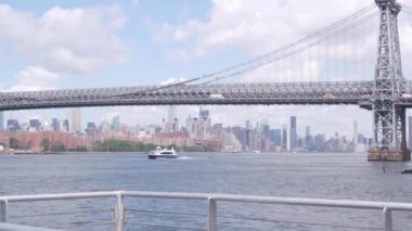 Feribottan New York City silueti. Manhattan şehir merkezindeki gökdelenler feribottan görünüyor. Doğu nehri kıyısı manzarası, nehir kıyısındaki binalar ABD suları yakınında. Williamsburg Köprüsü