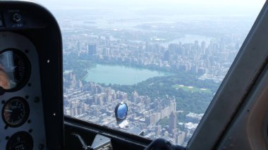 New York Şehri helikopter kabin uçuşu, ABD Manhattan üzerinde uçan helikopter kokpiti. Ekstrem turizm, ABD seyahati. Kamera titriyor. Central Park ve batı yakası yerleşim yerleri. Kontrol paneli.