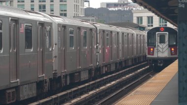 New York metro istasyonu. Metropolitan platformunda metro treni, Birleşik Devletler toplu taşımacılığı. Queens 'teki Court Square demiryolu hattında yükseltilmiş. New York yolcusu tren yolu trafiği, Long Island City