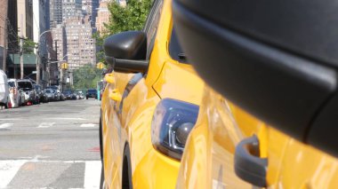 New York 'ta. Queens caddesindeki sarı taksiler. Long Island, LIC 'de bir sürü taksi var. Madalyon taksi ve Manhattan şehir merkezi şehir merkezi silueti. Yüksek binalı mimari.