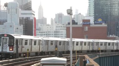 New York, ABD - 2 Eylül 2023 Metro İstasyonu. Metro treni toplu taşıma platformu. Yükseltilmiş dış demiryolu, Queens yolcu demiryolu trafiği, Long Island. Empire State Binası.