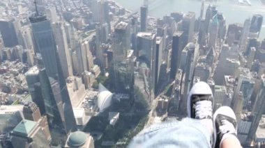 New York City 'nin kapıları helikopter uçuşuna kapalı. Helikopter Manhattan' ın üzerinde uçuyor. Dünya Ticaret Merkezi. Ayaklar spor ayakkabılarda, turist bacakları, ayakkabılar selfie pov. Amerika 'ya uçuk seyahat. Kamera sallanıyor..