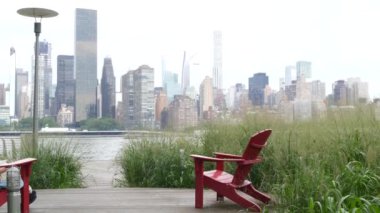 New York şehri kıyısı silueti, Manhattan şehir merkezi binaları, nehir kıyısındaki gökdelenler, doğu nehri suyu. Liman kenti manzarası, Gantry Plaza Park, Long Island, Queens. Birleşik Devletler. Koltuk sırası..