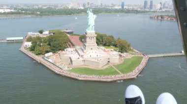 New York City 'nin kapıları helikopter uçuşuna kapalı, helikopter Amerika Birleşik Devletleri' nde Özgürlük Anıtı üzerinde uçuyor. - Evet. Spor ayakkabılı ayaklar, turist macerası, ayakkabılı bacaklar, selfie pov. Amerika 'ya git. Kamera sallanıyor..