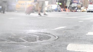 New York City Times Meydanı, Manhattan Midtown Broadway Caddesi, ABD. Amerikan NYC şehir hayatı. İnsanlar zebra yaya geçidinde yayalar. Yol trafiği. Düşük açılı bacak manzarası. Kanalizasyon kapağından çıkan sıcak duman.