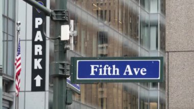 Beşinci cadde, 5 ave yolu tabelası, Manhattan şehir merkezi mimarisi, New York 5 av sokağı köşesi. Trafik kavşağı tabelası, ABD. Otopark ve Amerikan bayrağı.