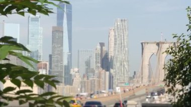 Arabalar Manhattan 'dan Dumbo' ya Brooklyn Köprüsü 'nde. New York City silueti, finans bölgesi şehir manzarası. Amerikan yol trafiği, insanlar, mimari. Dünya Ticaret Merkezi gökdeleni. ABD 'ye Seyahat.