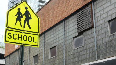 Okul bölgesi sarı yol işareti, yaya geçidi. New York 'ta çocuklar güvende. Ulaştırma ve eğitim sembolü, ABD. Queens, Long Island, Hunters Point 'te trafik işaretleri.