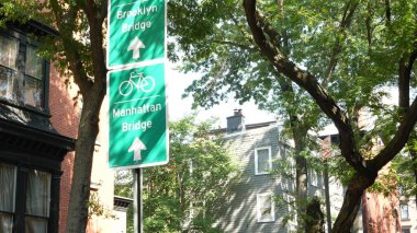 Bisiklet şeridi tabelası, Brooklyn Heights sokağı, New York. Manhattan Köprüsü bisiklet yolu, bisiklet yolu. Bisikletçiler yeşil yol işareti, ağaçlar. Eğlence amaçlı spor faaliyeti altyapısı, Birleşik Devletler.