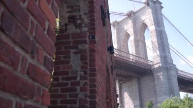 Dumbo 'dan New York City Brooklyn Köprüsü' ne. Kırmızı tuğla duvar, eski tarihi tütün deposu, Market ve Tiyatro. Düşük açı. Sembolik simge altında kemerli pencereler. Amerika Birleşik Devletleri, ABD mimarisi