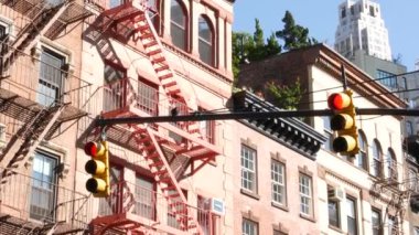 New York caddesi kavşağı, sarı trafik ışığı, ulaşım yolu kavşağı, Birleşik Devletler. Konut mimarisi. New York Emlak, yangın merdivenli kırmızı kahverengi tuğlalı ev. Manhattan.