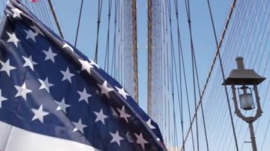 Brooklyn Köprüsü 'nden New York' a Amerikan bayrağı. Özgürlük, özgürlük, demokrasi ve bağımsızlığın vatansever sembolü, köprü kabloları. Amerika Birleşik Devletleri 'nin yıldızlı bayrağı rüzgarda savruluyor. ABD 'ye Seyahat.