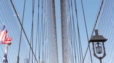Brooklyn Köprüsü 'nden New York' a Amerikan bayrağı. Özgürlük, özgürlük, demokrasi ve bağımsızlığın vatansever sembolü, köprü kabloları. Amerika Birleşik Devletleri 'nin yıldızlı bayrağı rüzgarda savruluyor. ABD 'ye Seyahat.