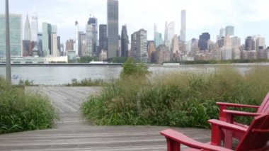 New York şehri kıyısı silueti, Manhattan şehir merkezi binaları, nehir kıyısındaki gökdelenler, doğu nehri suyu. Liman kenti manzarası, Gantry Plaza Park, Long Island, Queens. Birleşik Devletler. Koltuk sırası..