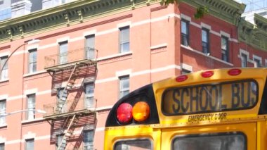 New York Manhattan caddesinde sarı okul otobüsü, şehir yolunda okul otobüsü kamyonu. Çocuk eğitim ve ulaşım, ABD. Amerikan okul servisi, 10 Avenue Chelsea kırmızı tuğlalı ev, Amerika Birleşik Devletleri.