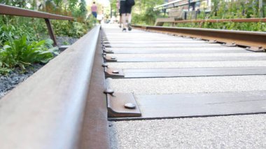 New York City High Line Greenway 'i yükseltti, Manhattan Midtown, ABD. Şehir parkındaki insanlar. Bahçedeki yeşillikte gezinti. Amerikan sokak hayatı, Hudson Yards yakınlarında Chelsea Highline. Demiryolu rayları.