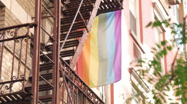 New York City mimarisi, Manhattan USA. Şehir dışındaki konutlar. LGBT gökkuşağı bayrağı, Birleşik Devletler. Tipik kırmızı tuğla cephesi. Yangın merdiveni. Homoseksüel sembolü. Gurur