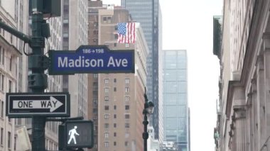 New York City kavşağı, Manhattan köşesi, Madison Bulvarı, sokak kavşağı tabelası. Midtown ilçesi yüksek mimarisi, Birleşik Devletler. Tek yönlü ok işareti, gökdelenler ve trafik ışığı.