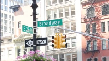 Broadway sokak tabelası, Manhattan şehir merkezi mimarisi, New York köşesi. Sarı trafik ışığı. Madison Square Park yakınlarındaki Flatiron bölgesinde. 23. Cadde, Bway ve 5. Cadde 'nin kesiştiği yerde. Tek yön