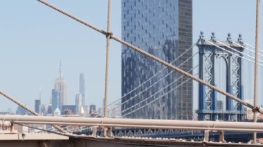 Brooklyn Köprüsü manzaralı New York City Manhattan Köprüsü. Şehir merkezindeki Empire State binası. ABD seyahat simgesi, New York silueti şehir manzarası. İkonik mimari kablolardan. Amerika Birleşik Devletleri 'ni Ziyaret Et.