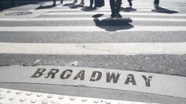 Broadway sokak tabelası, yaya zebra kavşağındaki insanlar. New York City Manhattan kavşağı. Yaya geçidinde asfalt, kavşaktaki gölgeler. Trafik levhası, Birleşik Devletler