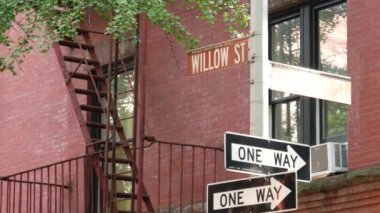 New York Şehri kavşağı, Brooklyn Heights Willow Caddesi kavşağı, tek yönlü tabela. Yerleşim bölgesi mimarisi, kırmızı tuğlalı ev, Birleşik Devletler. Merdiveni ve köşe metin yol işaretini ateşle.