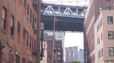 New York City Manhattan Köprüsü, Dumbo, Brooklyn Köprüsü. Brooklyn 'deki Plymouth caddesinde endüstriyel kırmızı tuğla binalar. Yangın merdivenli klasik NYC mimarisi. İki köprü turist manzaralı.