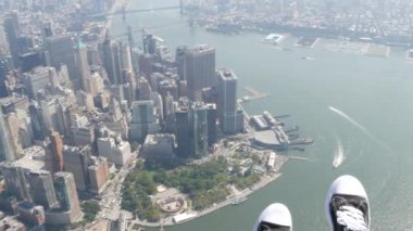 New York City 'nin kapıları kapalı helikopter uçuşu, helikopter Manhattan' ın üzerinde uçuyor, Fidi, ABD. Ayaklar ayakkabıda, bacaklar ayakkabıda, selfie pov. Ekstrem turist macerası, Amerika seyahati. Kamera sallanıyor..