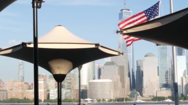 New York City rıhtımı, Manhattan şehir merkezi finans bölgesi, Dünya Ticaret Merkezi binası, nehir manzaralı gökdelenler. Amerikan bayrağı 11 Eylül anısına. New Jersey, ABD.