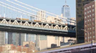 New York City Manhattan Köprüsü 'nden Brooklyn' e. Şehir merkezindeki liman kenti, 35. İskeleden ABD finans bölgesi gökdeleni. Doğu nehri ikonik manzarası, nehir kıyısında sabah gün batımı. Dünya Ticaret Merkezi