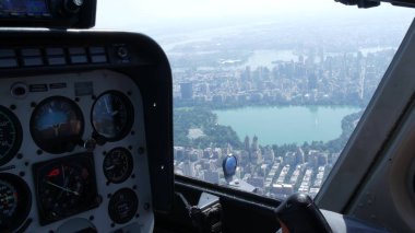 New York Şehri helikopter kabin uçuşu, ABD Manhattan üzerinde uçan helikopter kokpiti. Ekstrem turizm, ABD seyahati. Kamera titriyor. Central Park ve batı yakası yerleşim yerleri. Kontrol paneli.