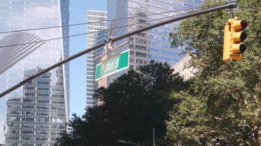 New York City crossroad, Fulton street intersection road sign. World Trade Center skyscraper, Manhattan downtown financial district architecture, NYC, United States. Yellow traffic light and roadsign. clipart