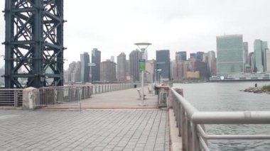 New York City rıhtımı silueti, Manhattan şehir merkezi, nehir kıyısındaki gökdelenler, doğu nehri suyu. Long Island, Queens 'teki Gantry Plaza rıhtımından rıhtım manzarası. Birleşik Devletler mimarisi.