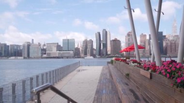New York şehri kıyısı silueti, Manhattan şehir merkezi binaları, nehir kıyısındaki gökdelenler, doğu nehri suyu. Waterside şehir manzarası, Hunters Point rıhtım kolonları, Long Island, Queens. Birleşik Devletler.