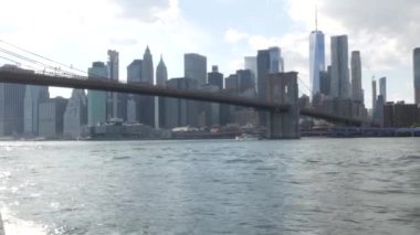 New York City, Manhattan şehir merkezi feribottan ufuk çizgisi. Brooklyn Köprüsü. Feribottan Dünya Ticaret Merkezi gökdelenine. Doğu nehri kıyısı manzarası, nehir kenarındaki binalar, ABD.