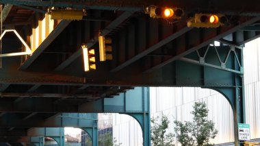 New York metrosu, metropol köprüsü, caddenin üstündeki metro yolu. Demiryolu taşımacılığı. Demiryolu hattı. Queens toplu taşımacılığı. Long Island City, Birleşik Devletler. Sarı trafik ışığı