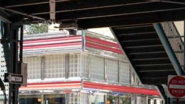 New York metrosu, metropol köprüsü, caddenin üstündeki metro yolu. Demiryolu taşımacılığı. Demiryolu hattı. Eski kafe, restoran. Court Square, Long Island City, Queens, ABD