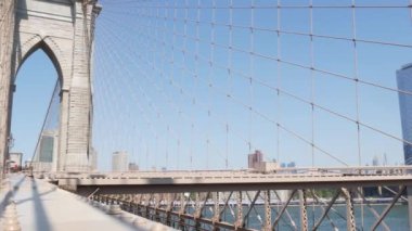 Brooklyn Köprüsü 'nden Manhattan' a, kablolar, mavi gökyüzü. New York 'un simgesel sembolü, ABD' nin seyahat hedefi. Amerika Birleşik Devletleri 'nin mimarisi, turist simgesi. Ünlü kablolu köprü vidaları.