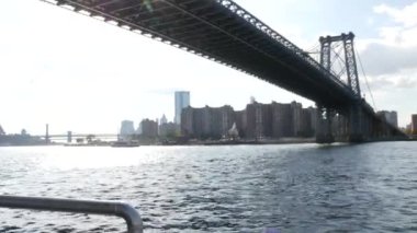 Feribottan New York City silueti. Manhattan şehir merkezindeki gökdelenler feribottan görünüyor. Doğu nehri kıyısı manzarası, nehir kıyısındaki binalar ABD suları yakınında. Williamsburg Köprüsü