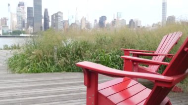 New York şehri kıyısı silueti, Manhattan şehir merkezi binaları, nehir kıyısındaki gökdelenler, doğu nehri suyu. Liman kenti manzarası, Gantry Plaza Park, Long Island, Queens. Birleşik Devletler. Koltuk sırası..