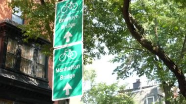 Bisiklet şeridi tabelası, Brooklyn Heights sokağı, New York. Manhattan Köprüsü bisiklet yolu, bisiklet yolu. Bisikletçiler yeşil yol işareti, ağaçlar. Eğlence amaçlı spor faaliyeti altyapısı, Birleşik Devletler.