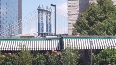 Manhattan Köprüsü 'nden Brooklyn Dumbo' ya. New York 'un sembolü, Amerika' nın seyahat yeri. Amerika Birleşik Devletleri 'nin mimarisi, turist simgesi. Kablolu yayın köprüsü. Park yeşili. Dumbo iskelesinin yanındaki kafe.