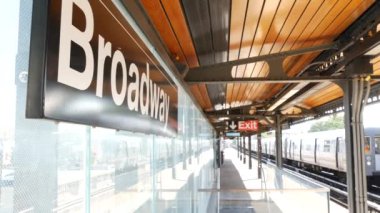 New York metro istasyonu Broadway mesaj tabelası. Metropolitan tren platformda, Birleşik Devletler metro taşımacılığı. Astoria, Queens 'teki yüksek demiryolu hattı. NYC yolcusu tren yolu trafiği.