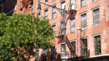 New York City klasik bina mimarisi, Manhattan, ABD. Şehir dışındaki konutlar. Birleşik Devletler 'de gayrimenkul. Tipik kırmızı tuğla cephesi. Yangın merdiveni. Tek yönlü ok işareti.