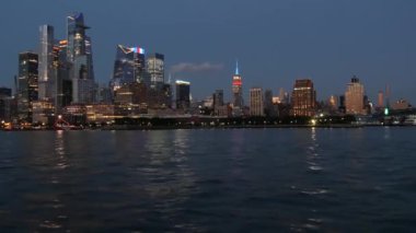 Nehir feribotundan New York City silueti. Manhattan Midtown, Hudson Yards feribotundan gökdelenler. Liman manzarası, nehir kenarı mimarisi, ABD. Akşam alacakaranlığı. Empire State Binası