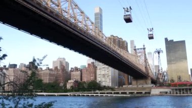 New York City Roosevelt Adası tramvayı Manhattan Midtown sokaklarına gidiyor. Queensboro Köprüsü yakınlarındaki Amerikan tramvayı. ABD 'de toplu taşıma. Yukarı doğu yakası mimarisi, ufuk çizgisi şehir manzarası.