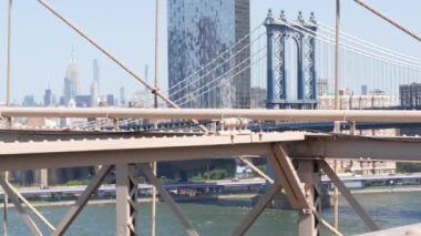 Brooklyn Köprüsü manzaralı New York City Manhattan Köprüsü. Şehir merkezindeki Empire State binası. ABD 'yi gezmek, turistik yerleri gezmek. New York Skyline şehir manzarası. Doğu Nehri suyunun üzerindeki ikonik mimari kablolardan..