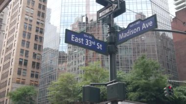 New York City kavşağı, Manhattan köşesi, Madison Bulvarı, sokak kavşağı tabelası. Midtown merkez bölgesi mimarisi, Birleşik Devletler. Tek yönlü ok işareti, gökdelenler. Düşük açı.