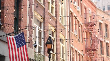 New York City mimarisi. Evin dış cephesi. Gayrimenkul, Amerikan bayrağı. Tipik kırmızı tuğla cephesi. Manhattan şehir merkezi finans bölgesi, Stone Caddesi, FiDi. Yangın merdiveni